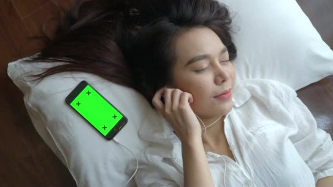 女人睡在带移动绿屏的枕头上