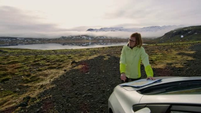 WS女人，地图站在车外，俯瞰冰岛偏远的风景