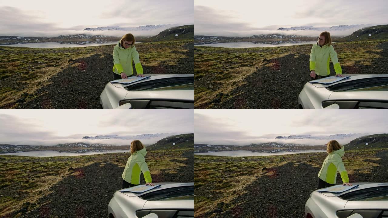 WS女人，地图站在车外，俯瞰冰岛偏远的风景