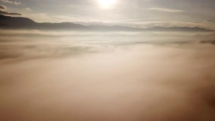 山上的日出鸟瞰图和多云的移动雾