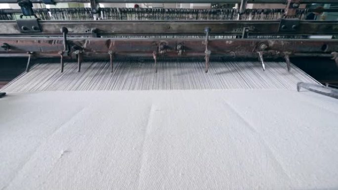自动化机器在纺织设施中编织织物。