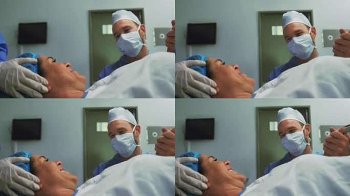 高加索男子在医院手术室分娩时安慰孕妇的前视图