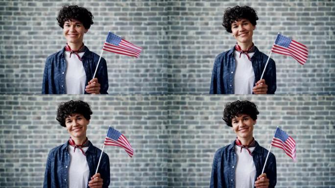 骄傲的美国公民在砖块背景上微笑着举着国旗的慢动作