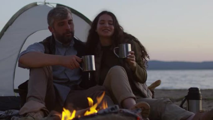 夫妇在海滩露营地用热水瓶喝茶