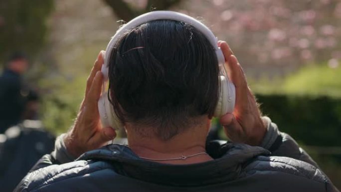 成熟的男人在公园听音乐
