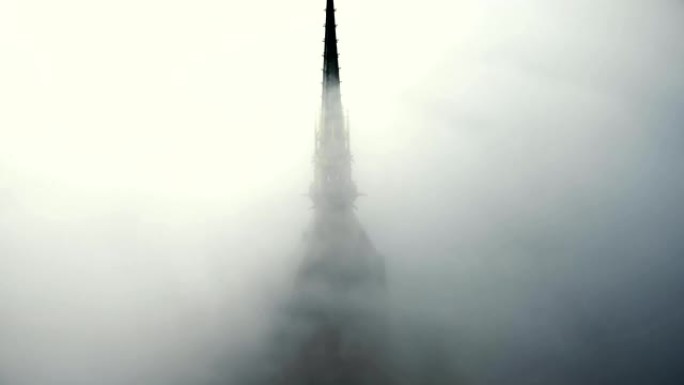 无人机升起在雾云之上，在标志性的圣米歇尔要塞城堡尖顶上展现史诗般的金色雕像。