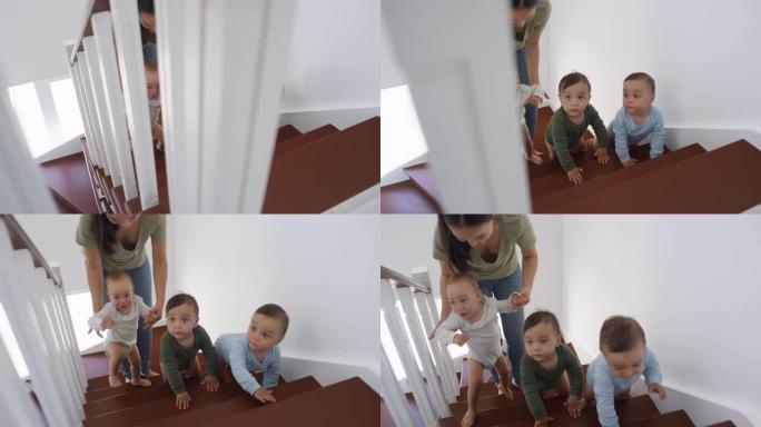 亚洲蹒跚学步的三胞胎爬上楼梯，妈妈帮忙