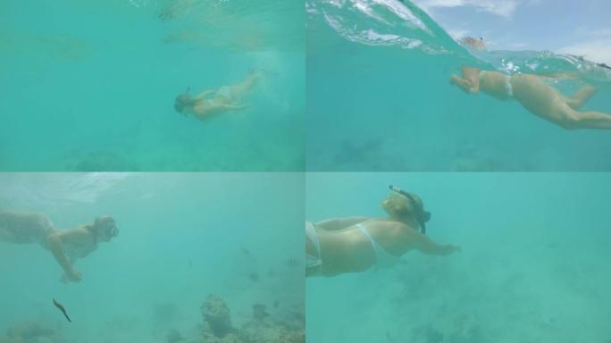 POV拍摄一个女人在美丽的绿松石水中浮潜