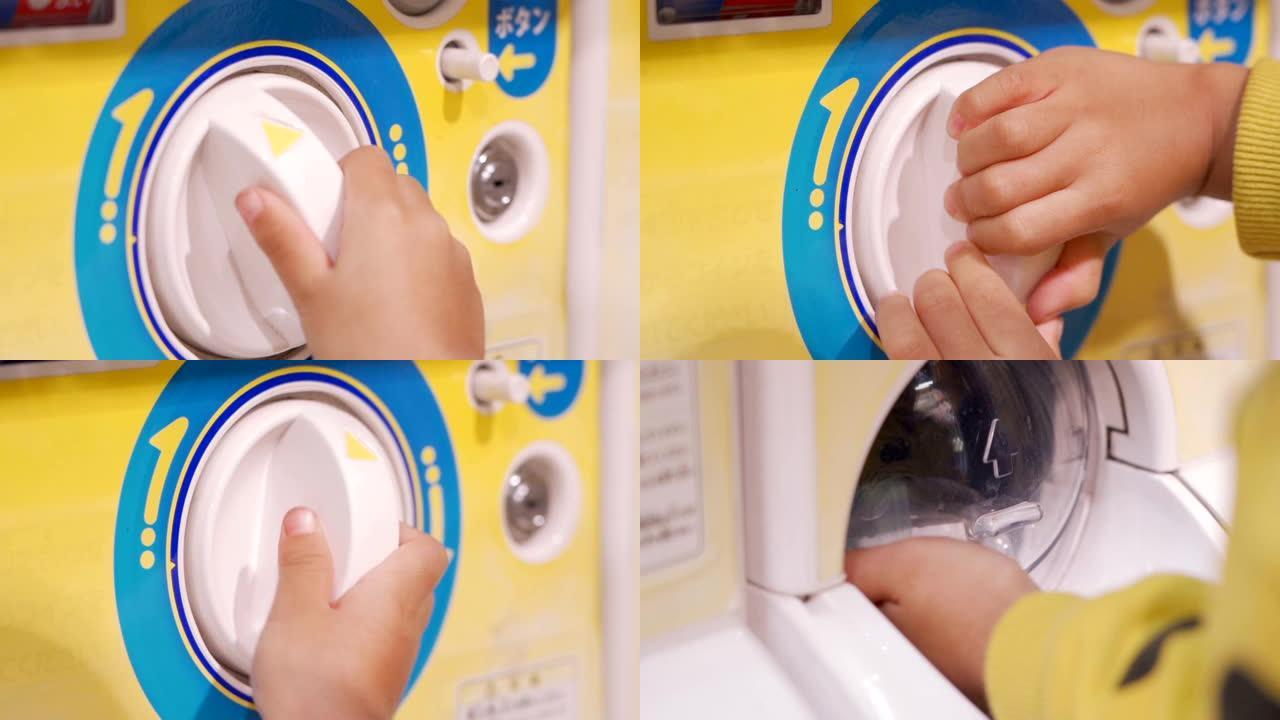 小孩手在日本购买gachapon玩具自动售货机。