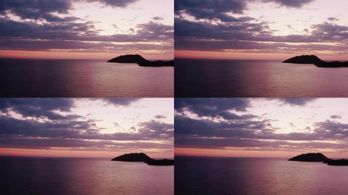 日落时海中一个荒岛的鸟瞰图。