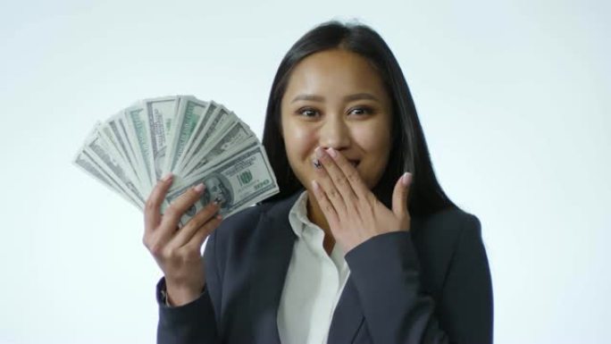 惊讶的亚洲女商人与白色背景上的美元钞票粉丝合影