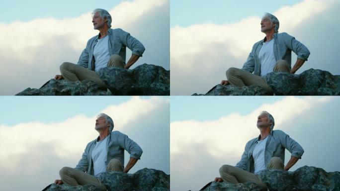 高级男子在4k乡村的一块岩石上放松