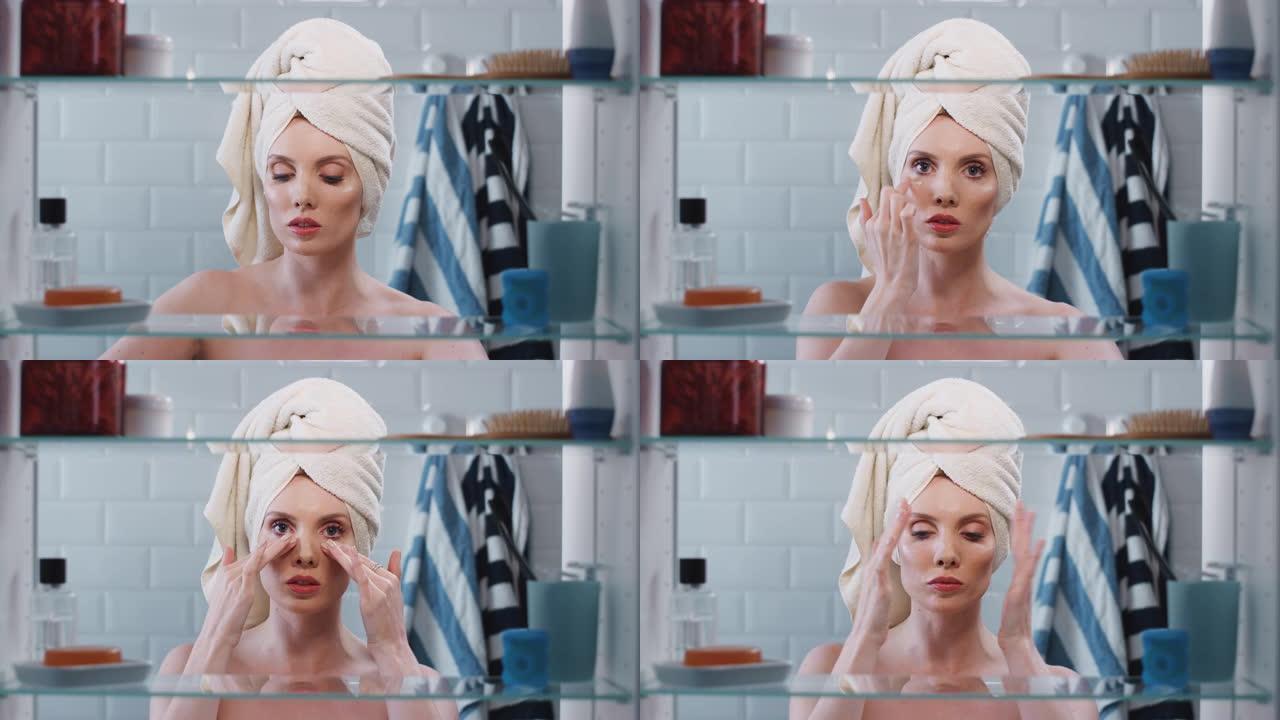 透过浴室柜，可以看到戴着毛巾在头上化妆的女人