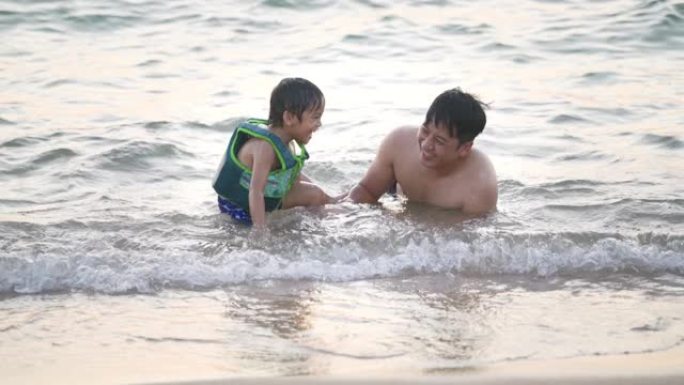 一位父亲教儿子在海滩上游泳