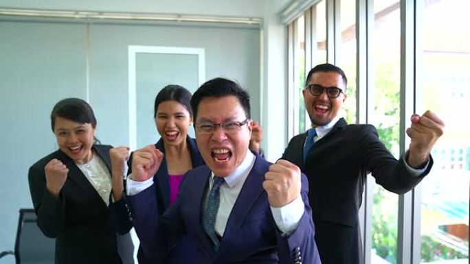 一群快乐的商人表现出成功的迹象。成功的商业团队竖起大拇指。