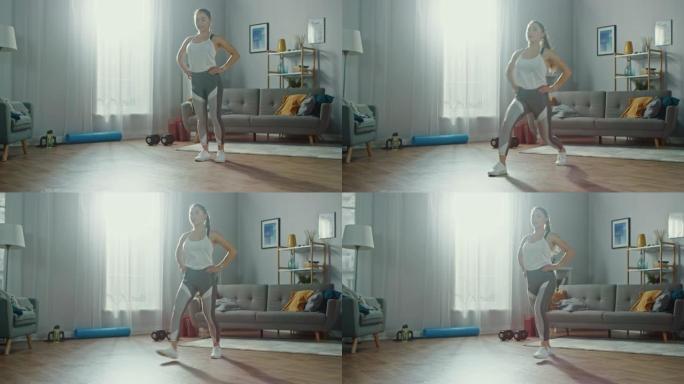 穿着运动服的强壮美丽的运动健身女孩正在她明亮宽敞的公寓里做向前的弓步运动，室内简约。