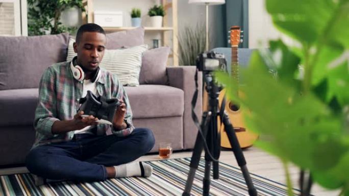 非裔美国人博客作者正在家里用相机录制vlog。