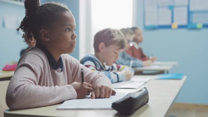 在小学教室里，聪明的黑人女孩在练习笔记本上写字，参加考试。初中教室里有各种各样聪明的孩子，勤奋学习。
