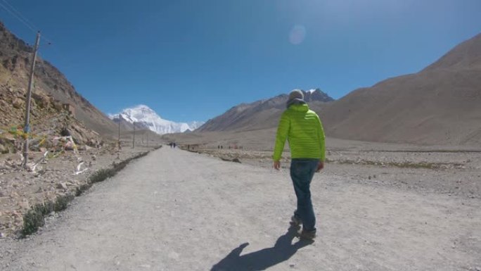 镜头耀斑: 男性旅行者开始徒步前往白雪皑皑的珠穆朗玛峰。