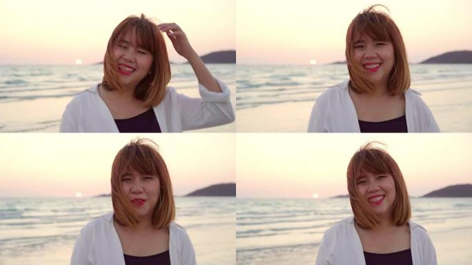 年轻的亚洲女人在海滩上感到快乐，美丽的女性快乐放松微笑在海滩附近的海边当日落在傍晚。生活方式女性旅行