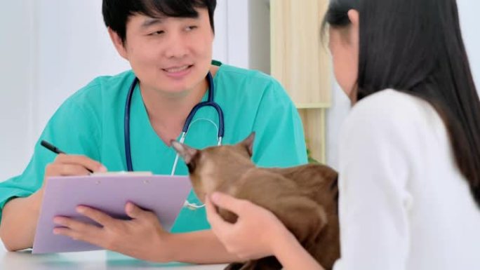 亚洲少女带宠物听亚洲男性兽医医生在诊所咨询她。兽医，关系，人，医疗保健和医学，宠物爱情概念