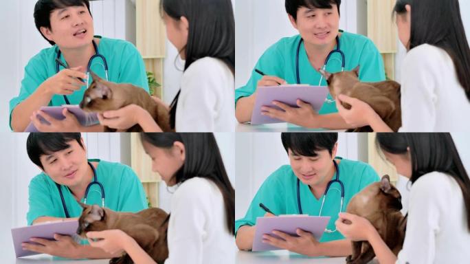 亚洲少女带宠物听亚洲男性兽医医生在诊所咨询她。兽医，关系，人，医疗保健和医学，宠物爱情概念