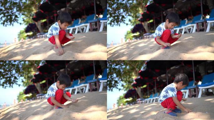 泰国芭堤雅海滩上的亚洲小男孩采摘贝壳