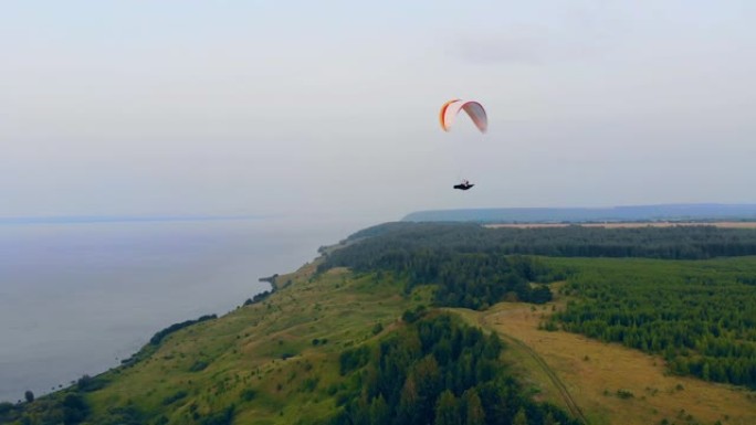 翼伞沿着森林海岸线滑行。天空中的滑翔伞。