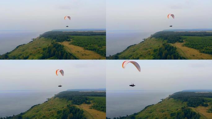 翼伞沿着森林海岸线滑行。天空中的滑翔伞。