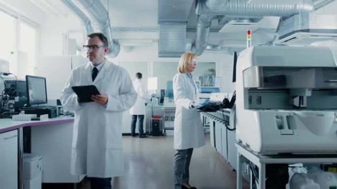 研究团队的科学家在计算机上工作，与医疗设备，分析血液和遗传物质样本与特殊的机器在现代实验室。
