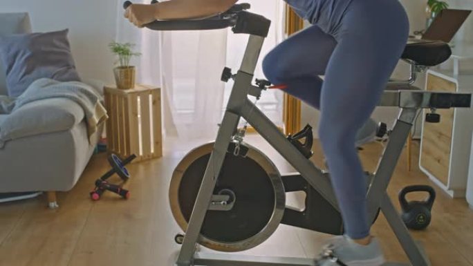 SLO MO女人在家里的健身车上锻炼