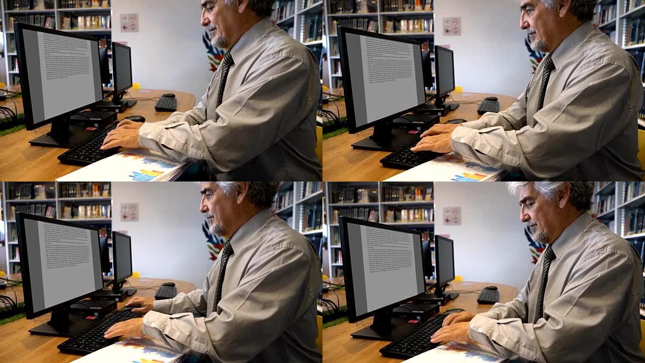 成人老师在图书馆使用计算机处理文档