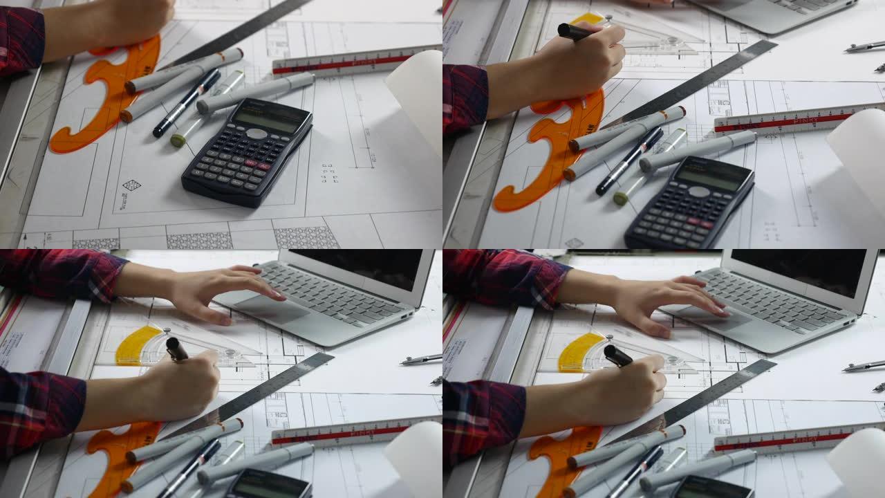 建筑师用笔记本电脑检查图纸工作的手
