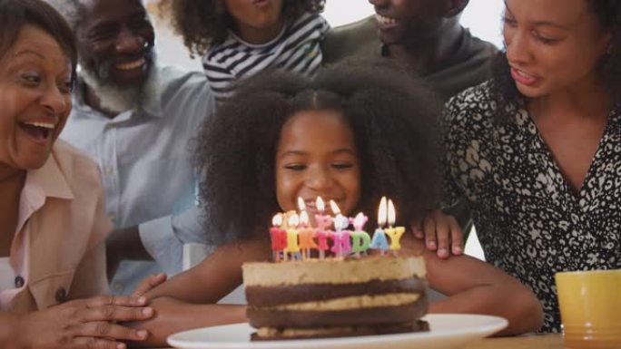 多代家庭在家用蛋糕和蜡烛庆祝孙女生日