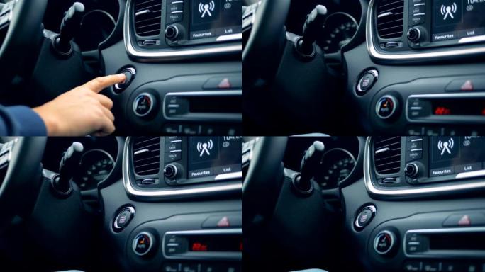 男性的手通过按下按钮来启动和停止汽车的发动机
