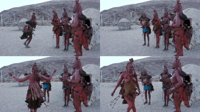 纳米比亚，穿着传统服装的辛巴族妇女在他们的粘土小屋外跳舞唱歌的4K画面