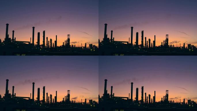 WS剪影的炼油厂塔在日落的天空中