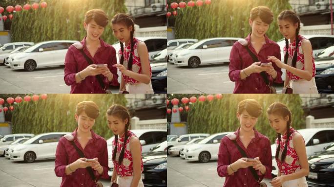 年轻的亚洲夫妇在城市街道上使用智能手机进行自画像