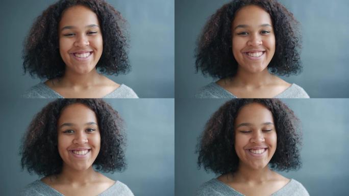 快乐的非洲裔美国学生在黑色背景上微笑的肖像感到快乐