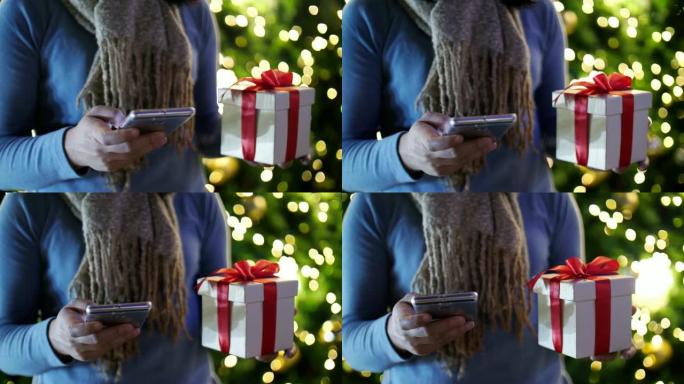 女人用手机和礼品盒庆祝圣诞节和新年，慢动作