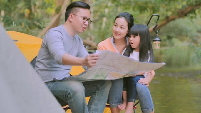 亚洲小女孩在露营旅行中兴奋，地图上寻找自然绿色森林的冒险。亚洲家庭教小女孩关于森林中的可持续性。教孩