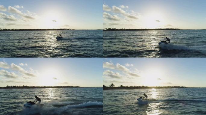 4k鸟瞰图，男子在海洋中乘坐私人船只玩得开心，太阳落到海浪上，莫桑比克