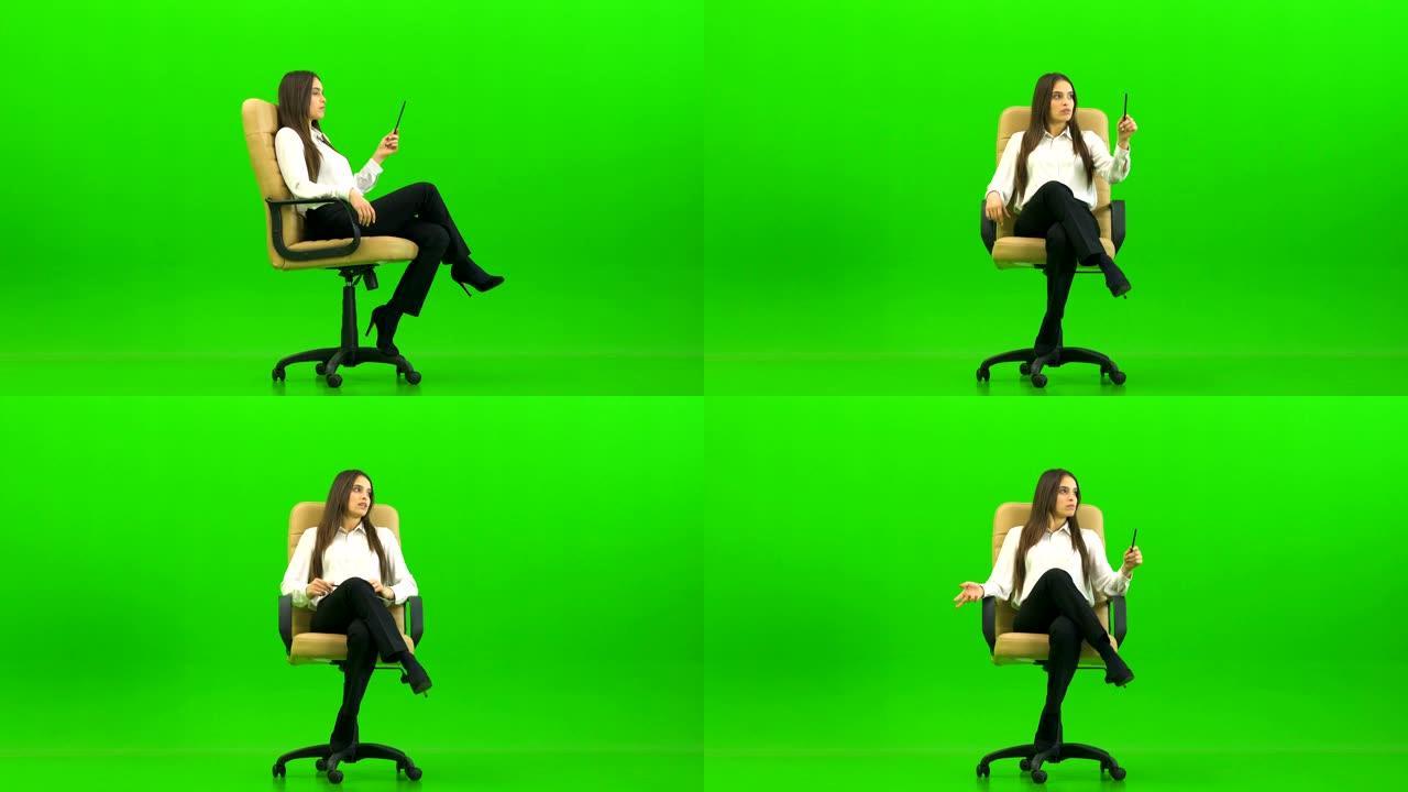 办公室椅子上的美女在绿色背景上聊天