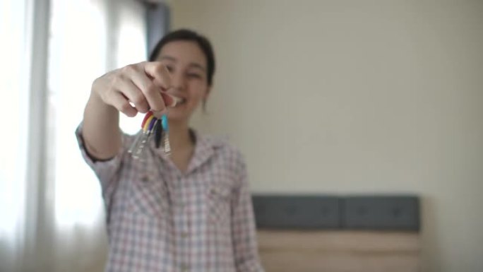 亚洲女性展示钥匙交房新家乔迁之喜