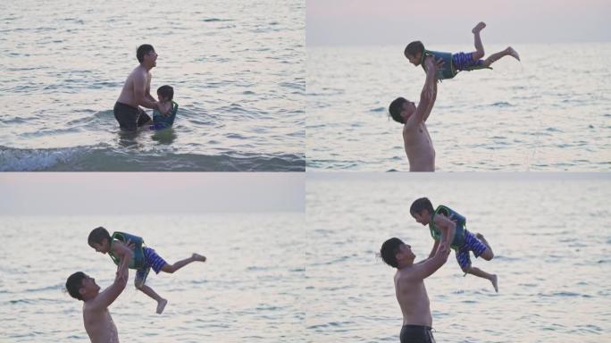 一位父亲在海滩上举起儿子