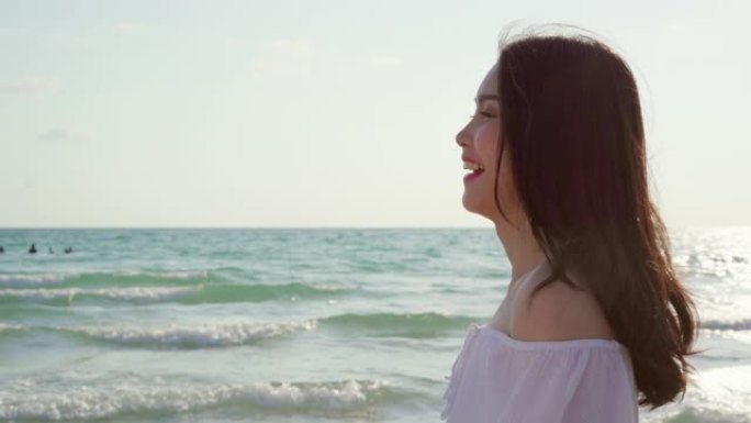 年轻的亚洲女人在海滩上散步。晚上日落时，美丽的女性快乐放松在海边的海滩上散步。生活方式女性在海滩上旅