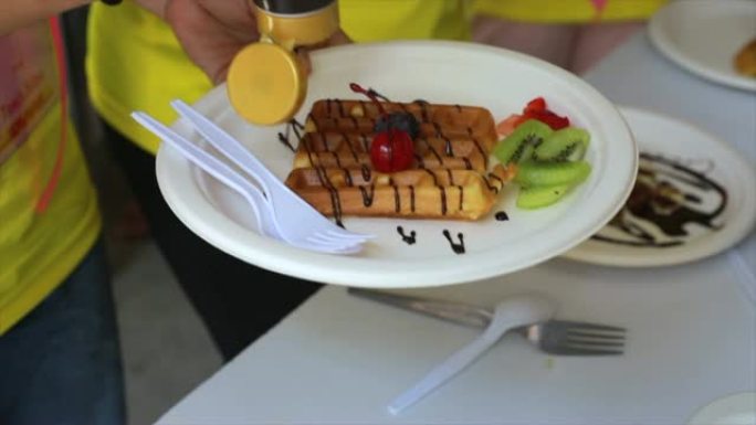 Pouring syrup on a waffle
