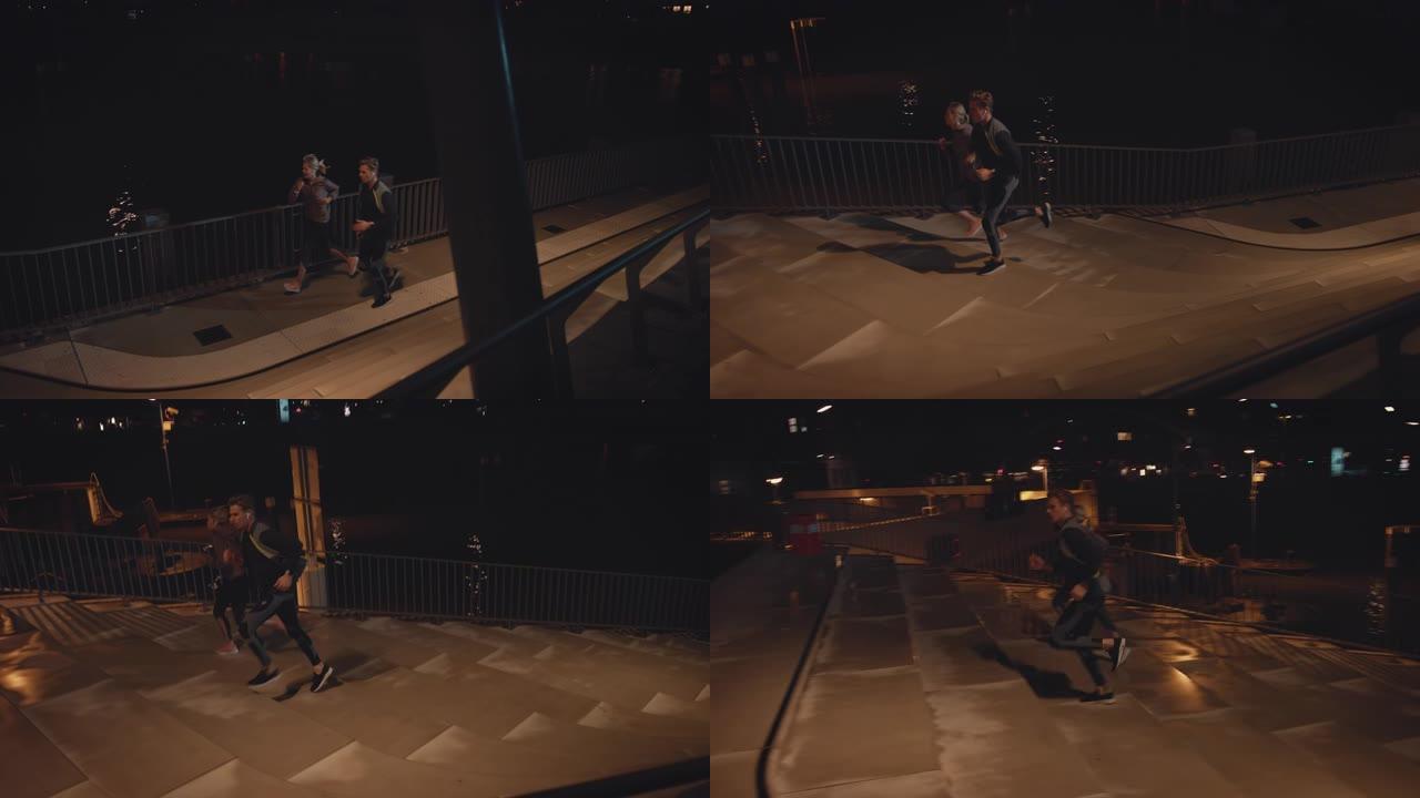 年轻夫妇晚上在城市的台阶上奔跑