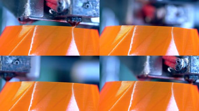 3d打印机的头部正在创建橙色薄层。3D打印机在3d打印实验室工作。