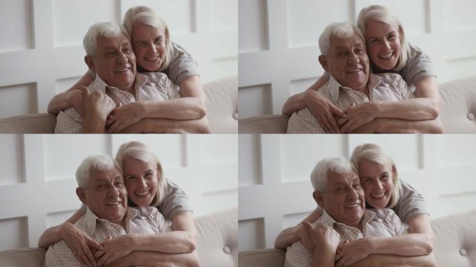 微笑的中年妇女拥抱80年代快乐的退休父亲。